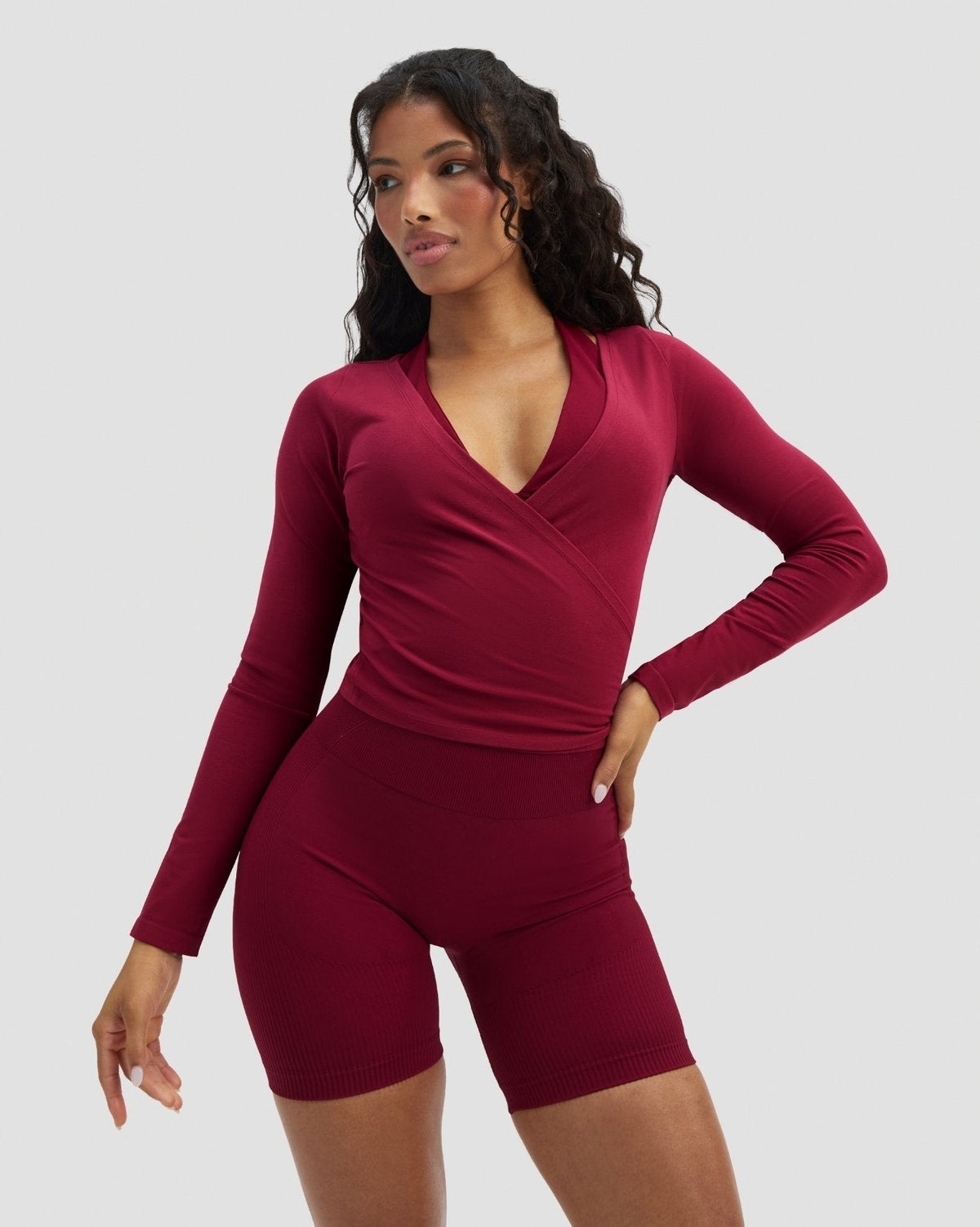 The Essential Collection Wrap Top in Raspberry, front view with hand on hip, styled with matching shorts