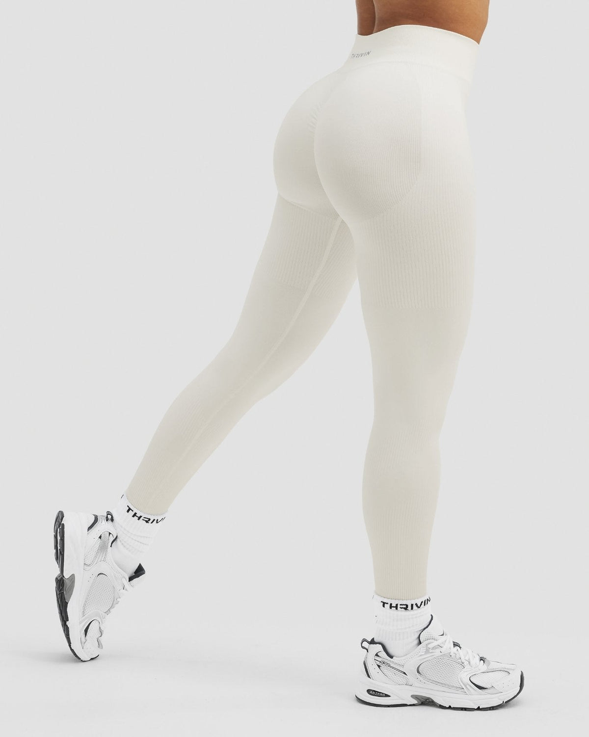 Elevate Sculpting Mid Waist Scrunch Leggings in Cream, side view mid-stride with white sneakers