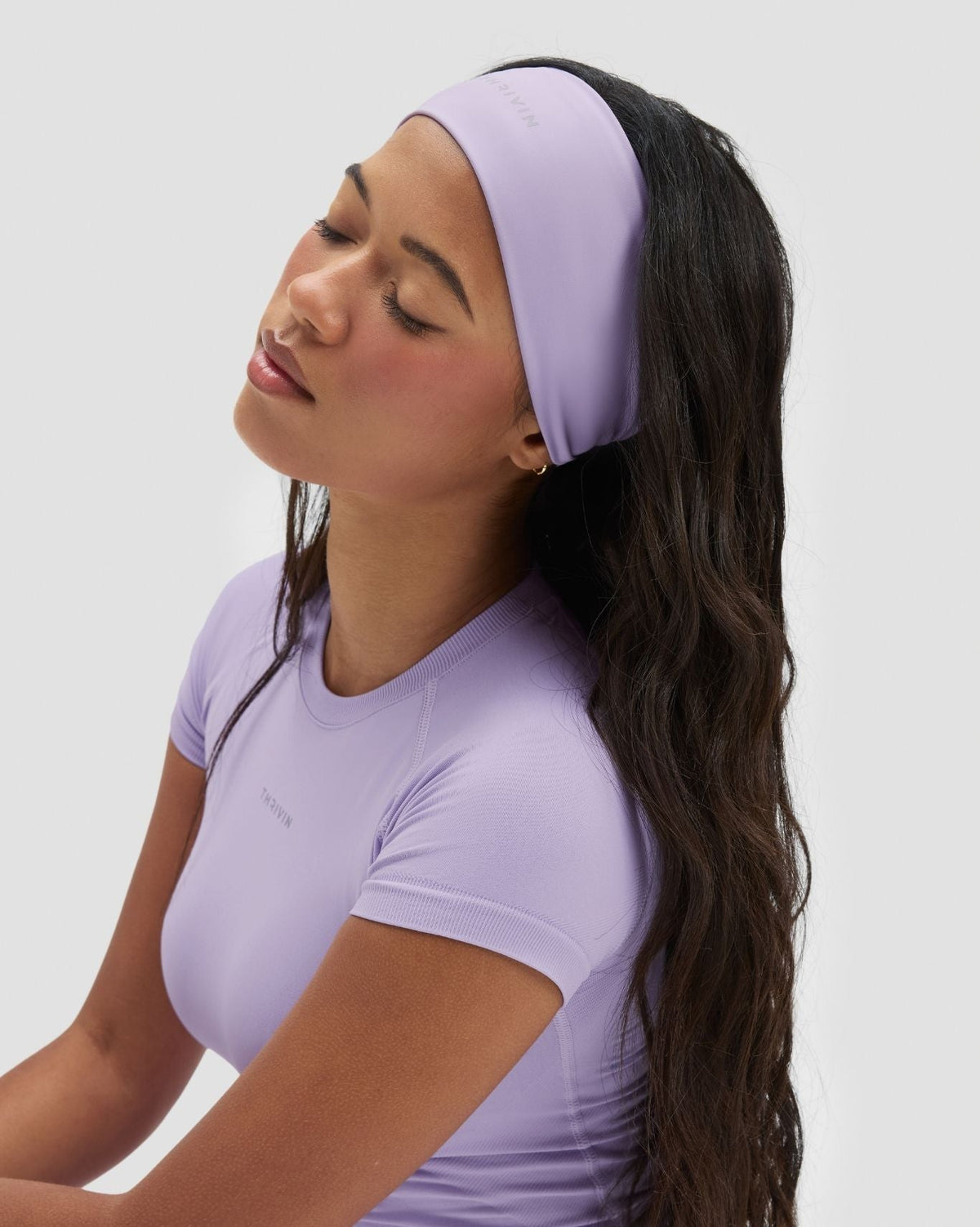 The Essential Collection Chrome Logo Headband in Lilac, three-quarter view of wide band styled with matching top