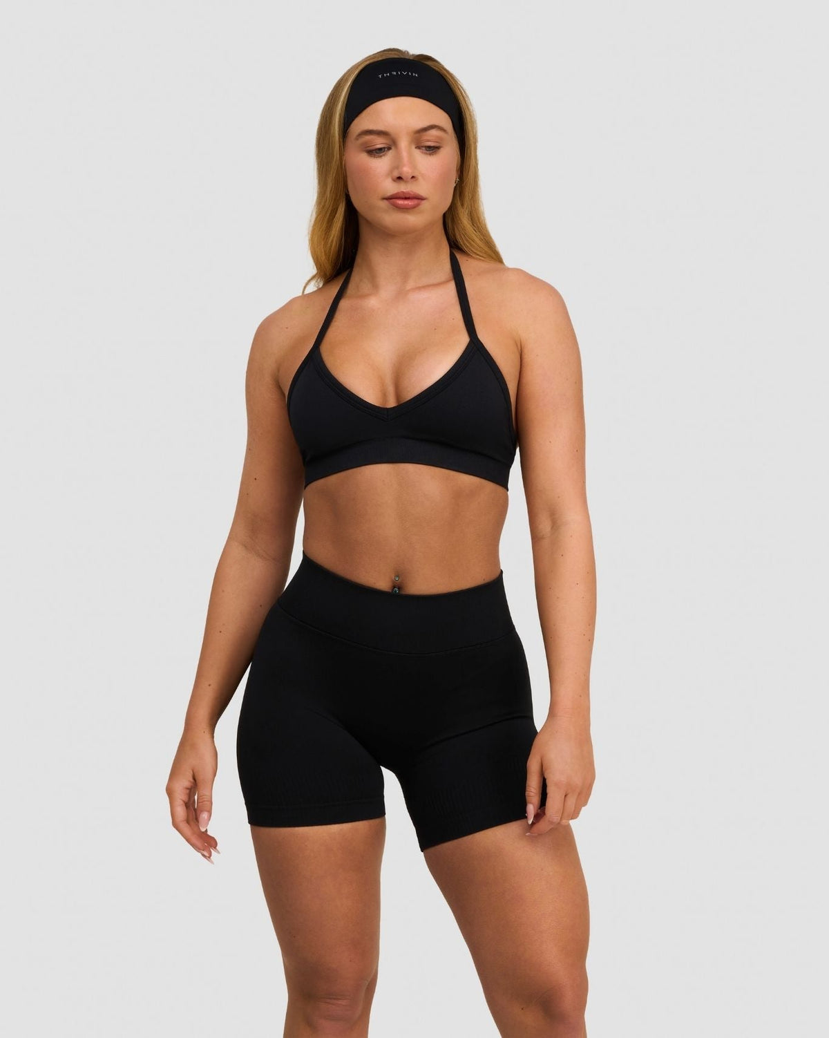 Elevate Sculpting Seamless Adjustable Halter Bra in Night Black, front view with halter ties, styled with matching shorts