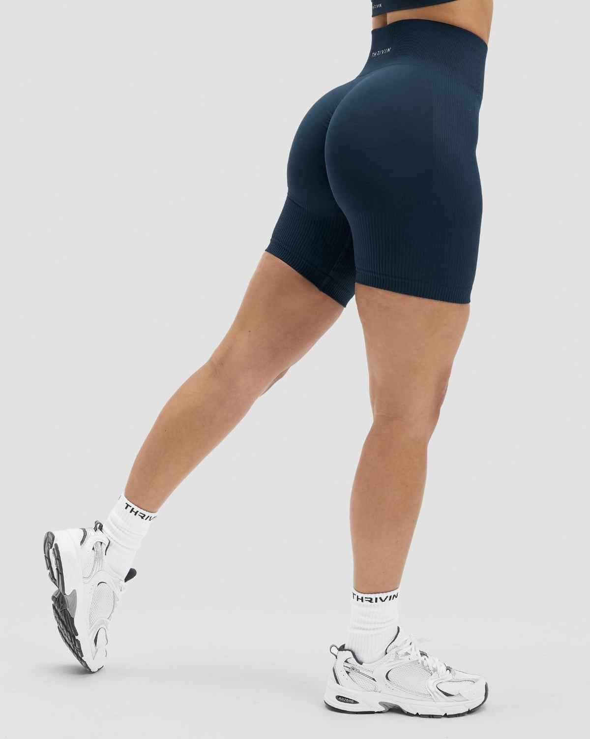 Elevate Sculpting High Waist Scrunch Shorts in Midnight Navy Blue, back three-quarter view of high waistband, mid-stride