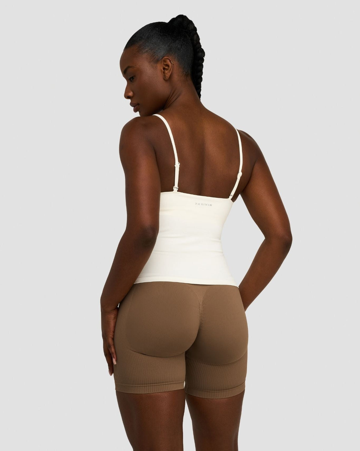 Elevate Sculpting Seamless Scoop Neck Cami in Cream, three-quarter back view with thin straps, styled with brown shorts
