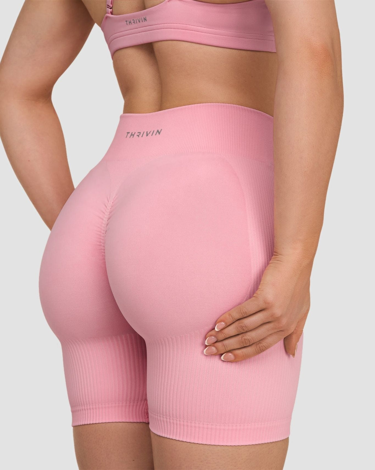 Elevate Sculpting Mid Waist Scrunch Shorts in Cotton Pink, back close-up of scrunch seam and THRIVIN logo waistband