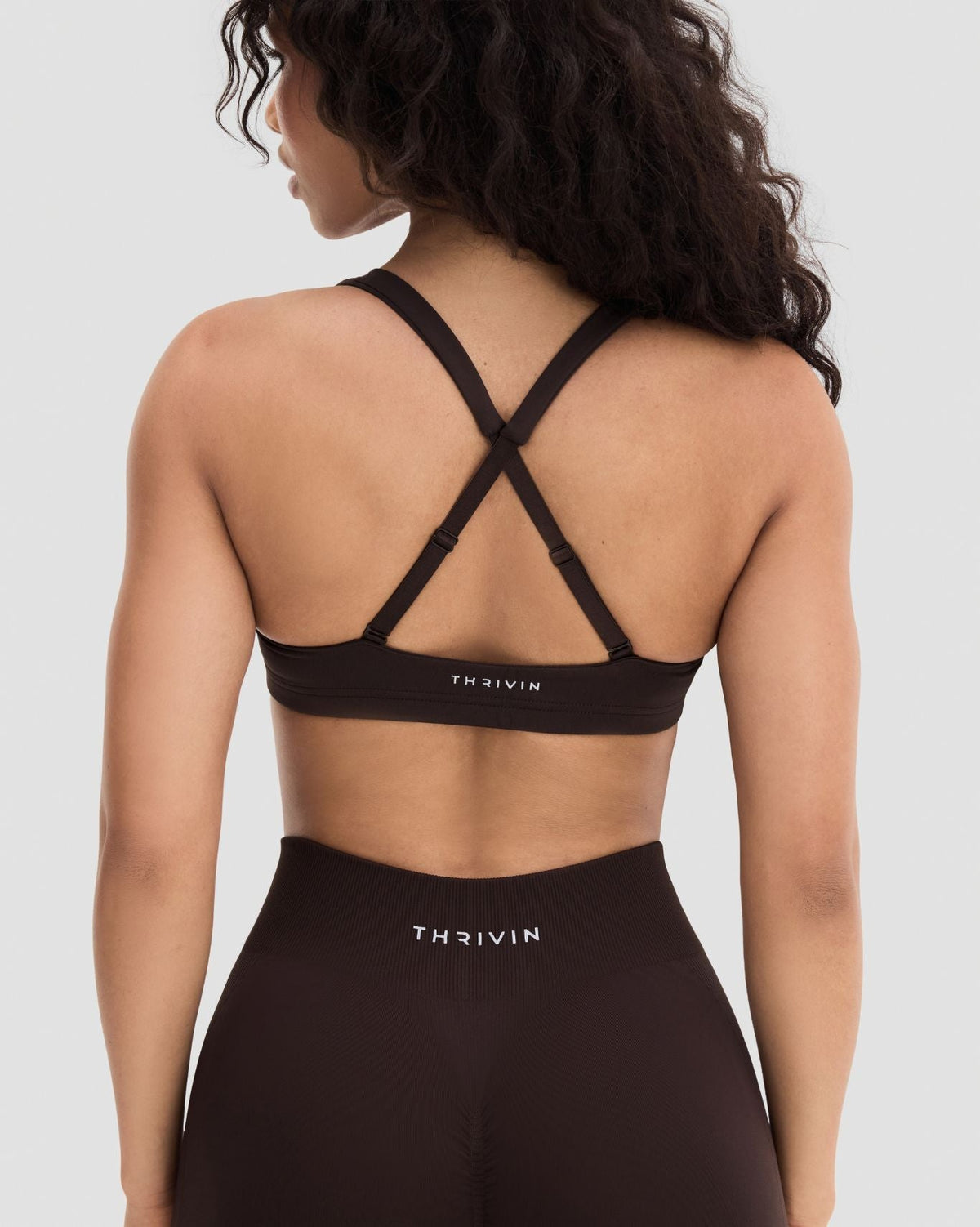 Elevate Sculpting Medium Impact Multiway Bra in Coffee Brown, back close-up of crossed straps and THRIVIN logo waistband