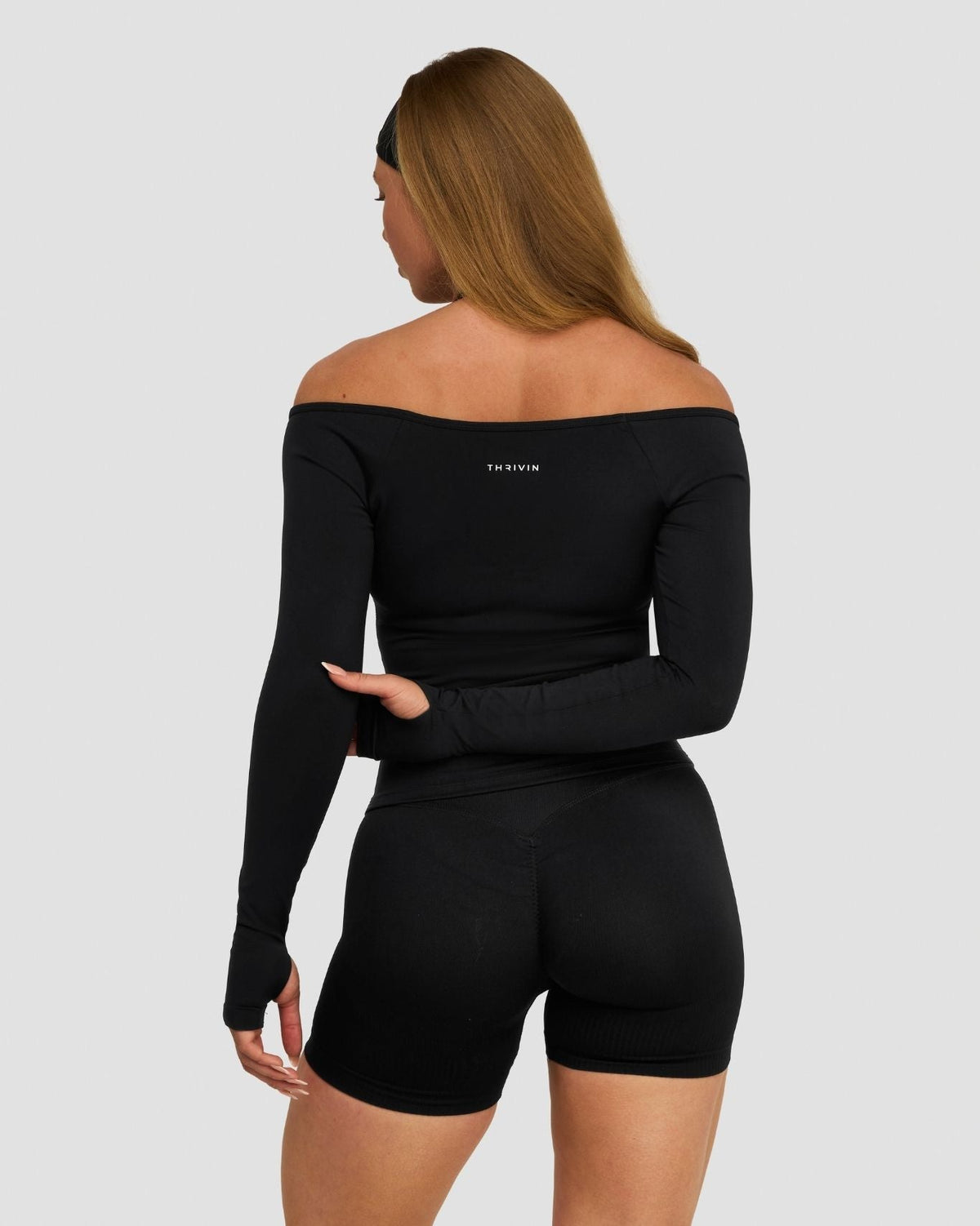 Elevate Sculpting Seamless V-Neck Top in Night Black, back view with off-shoulder neckline and thumbholes, with shorts