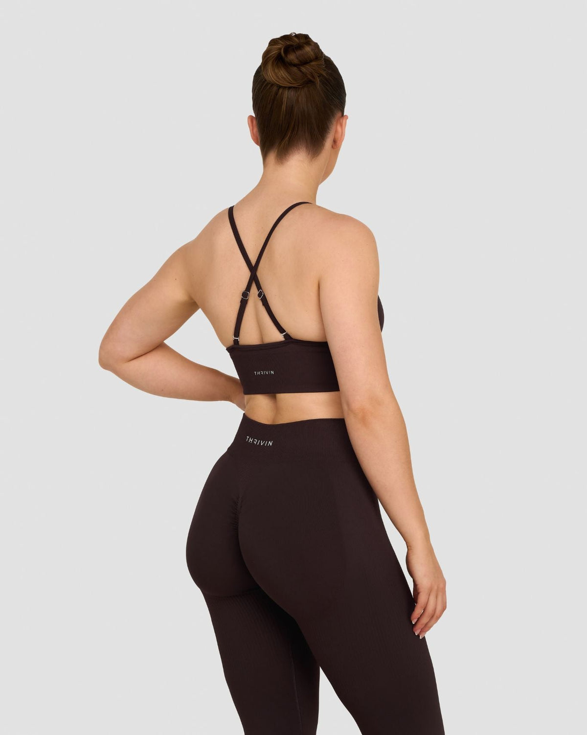 Elevate Multiway Sculpt Seamless Bra in Coffee Brown, back view with crisscross straps, styled with leggings