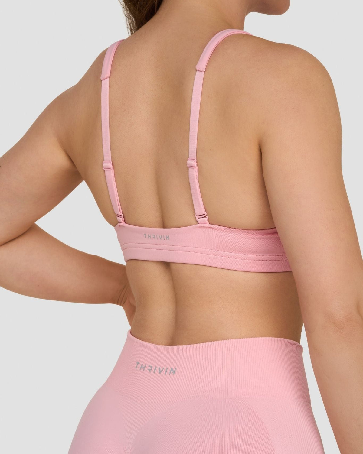 Elevate Sculpting Medium Impact Multiway Bra in Cotton Pink, back close-up of straps and THRIVIN waistband