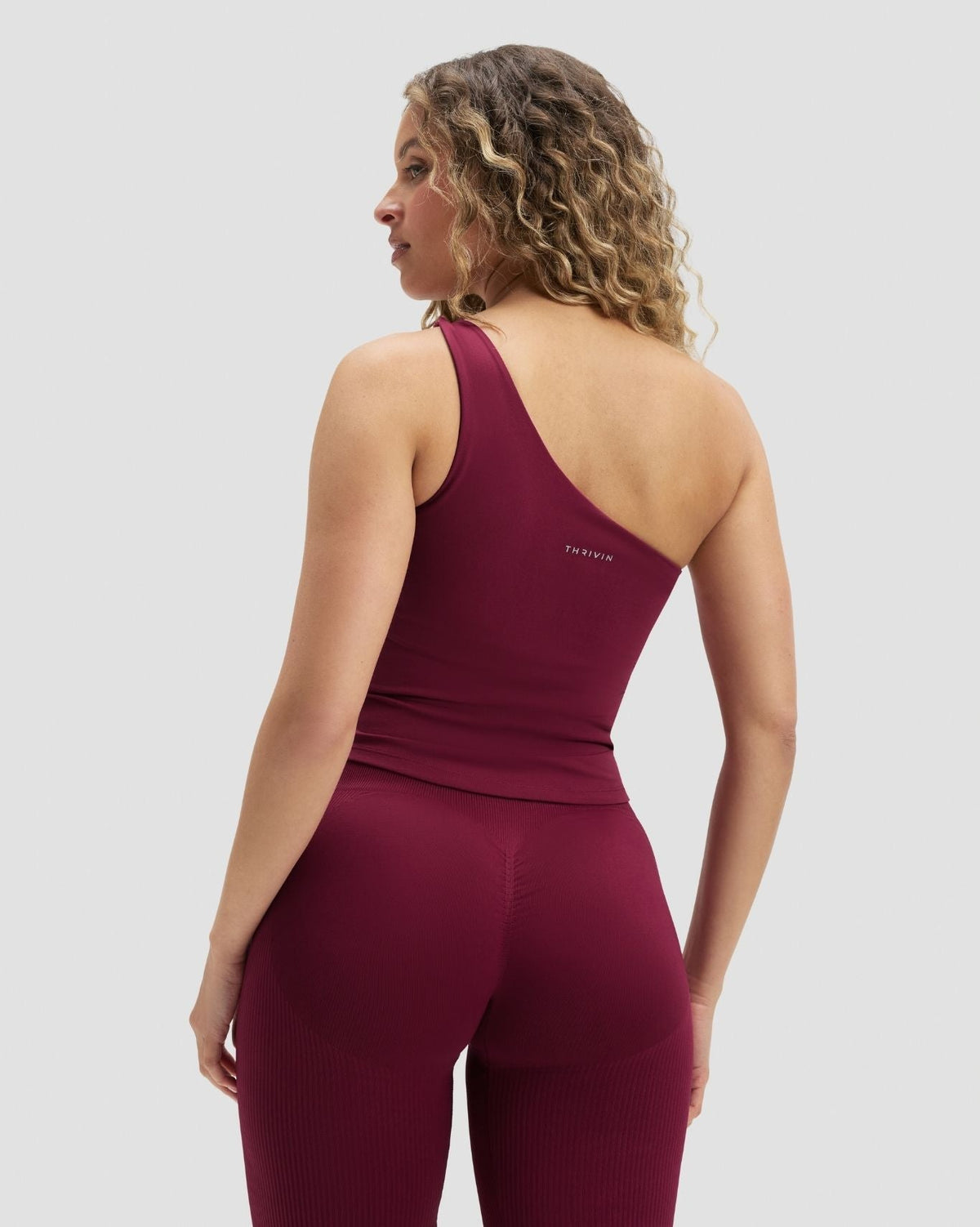 Elevate Sculpting Asymmetric Twist Top in Cherry Berry, back view of one shoulder strap