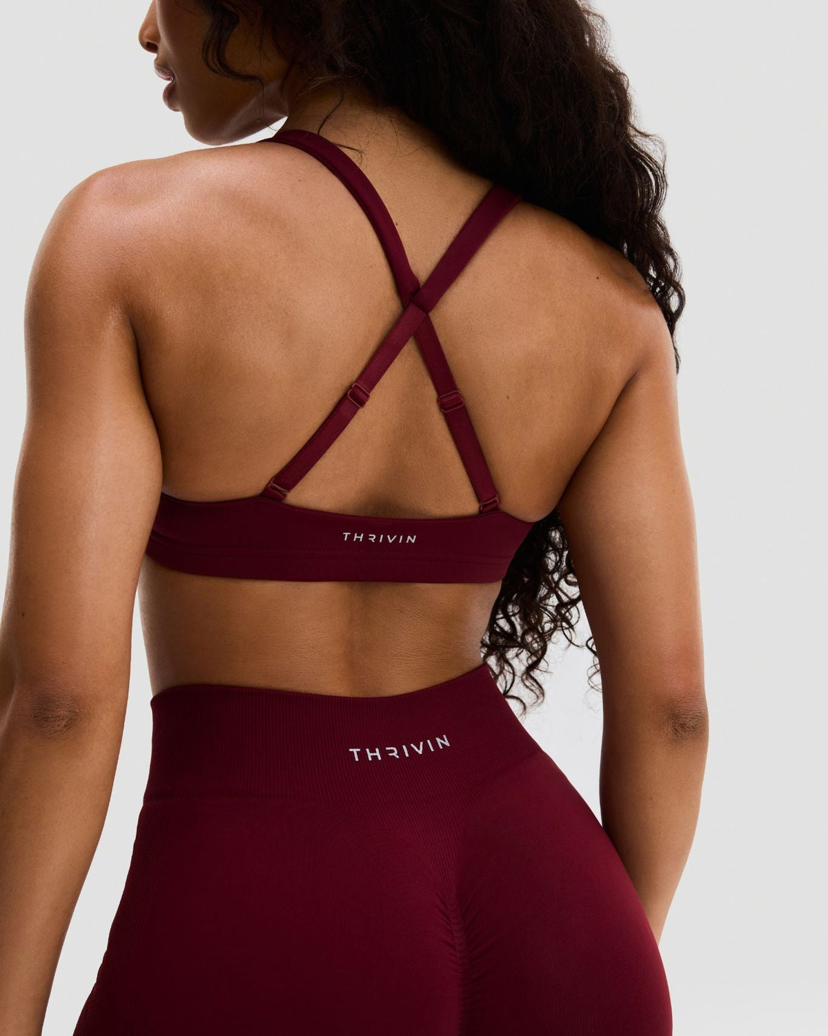 Elevate Sculpting Medium Impact Multiway Bra in Fine Wine Red, back close-up of crossover straps and THRIVIN logo