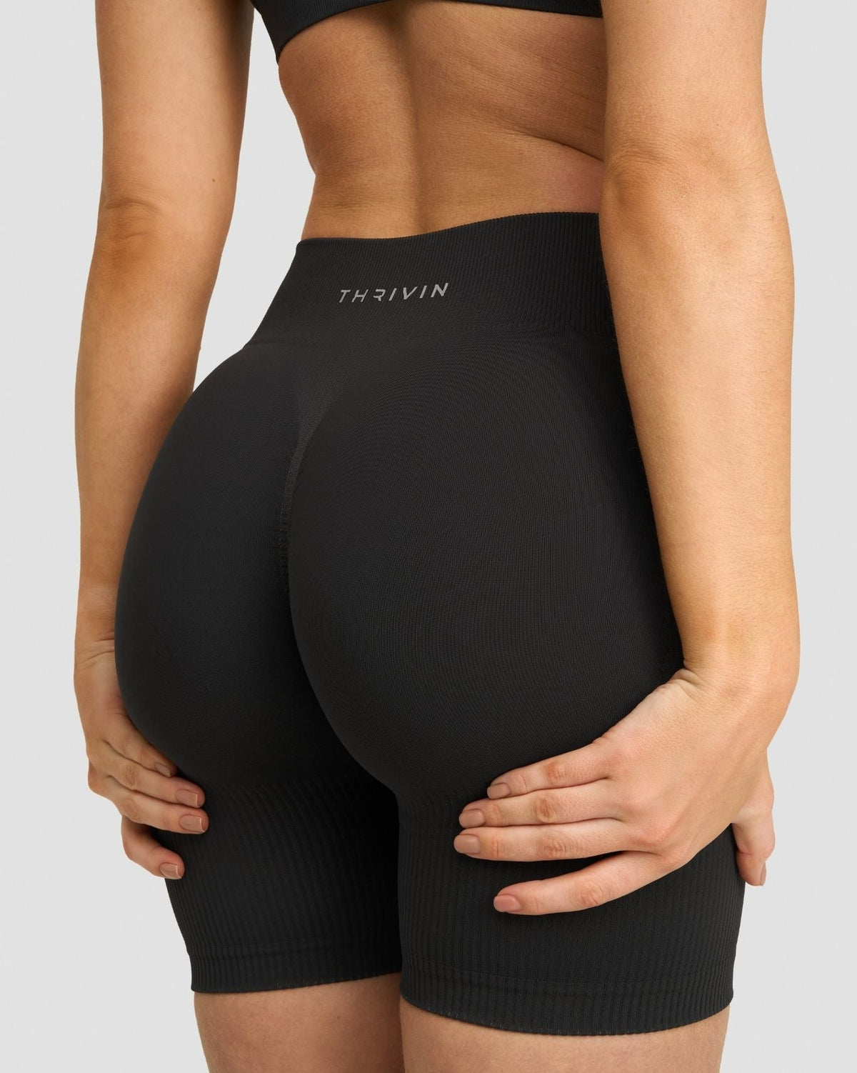 Elevate Sculpting Mid Waist Scrunch Shorts in Charcoal Grey, back close-up of waistband with THRIVIN logo and scrunch seat