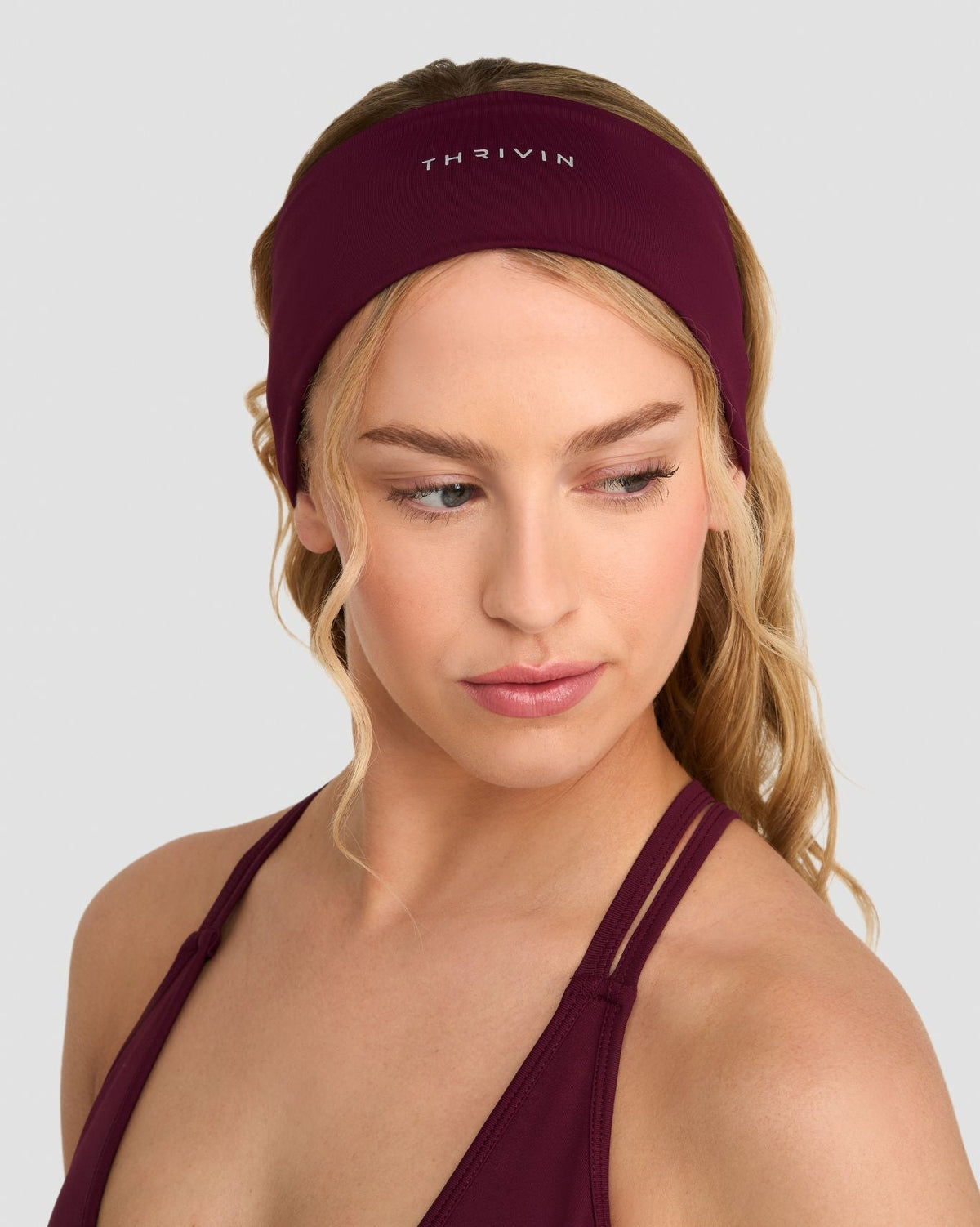 The Essential Collection Chrome Logo Headband in Merlot, front close-up worn on head with THRIVIN logo