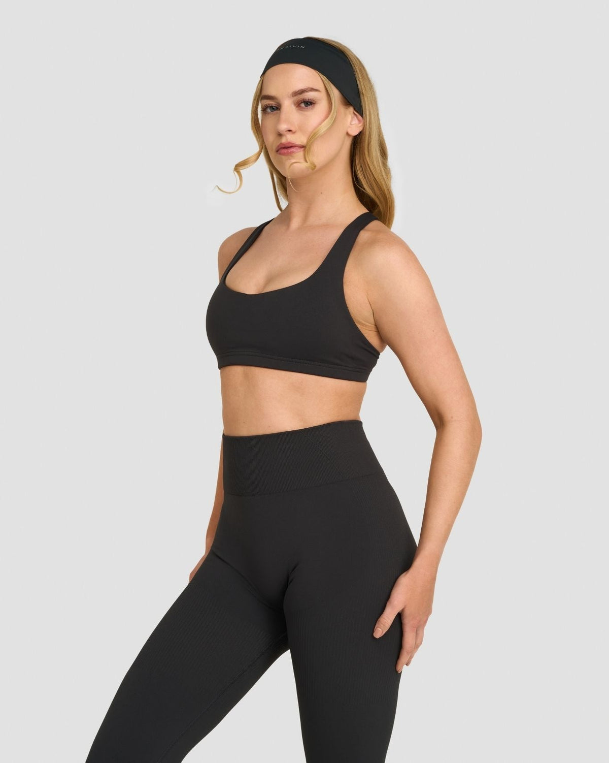 Elevate Sculpting Medium Impact Multiway Bra in Charcoal Grey, three-quarter front view of scoop neckline, with leggings
