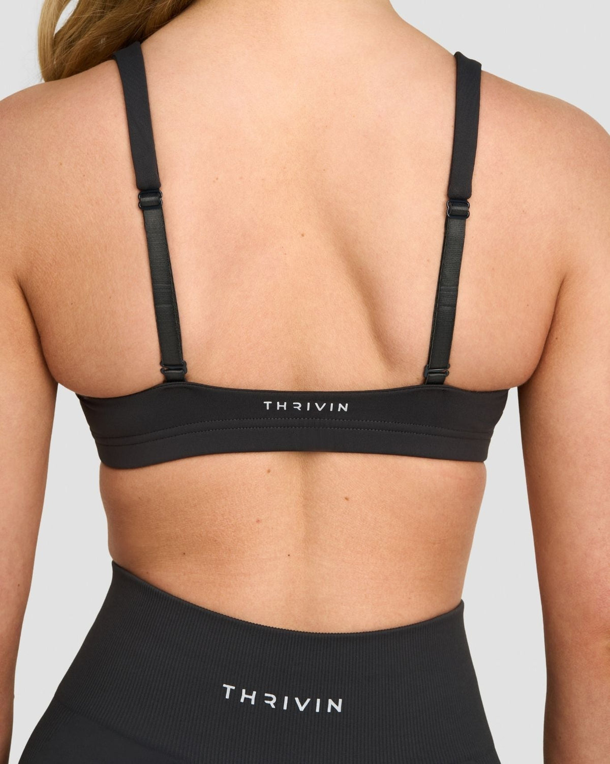Elevate Sculpting Medium Impact Multiway Bra in Charcoal Grey, back close-up of straps and THRIVIN logo band