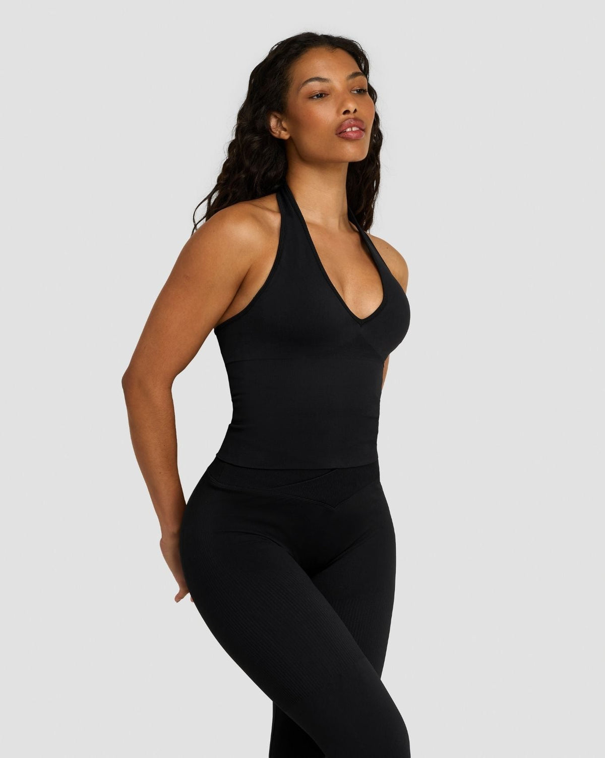 Elevate Sculpting Seamless Halterneck Top in Night Black, three-quarter front view with halter V-neck and black leggings