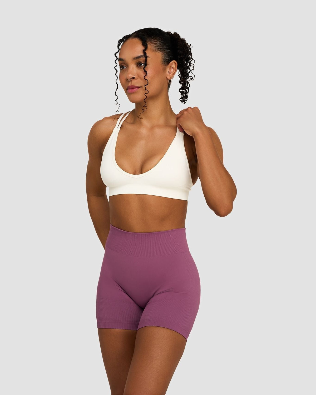 Elevate Sculpting Mid Waist Scrunch Shorts in Orchid Mauve, front view styled with cream sports bra