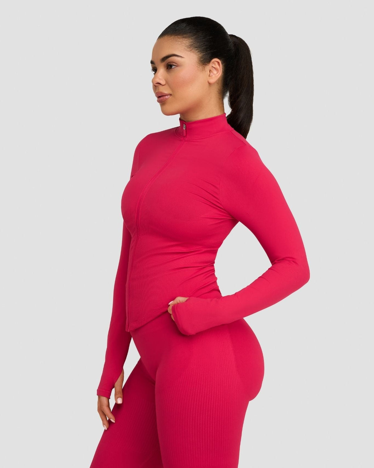 Elevate Compression Long Sleeve Jacket in Strawberry, side three-quarter view with thumbhole sleeve