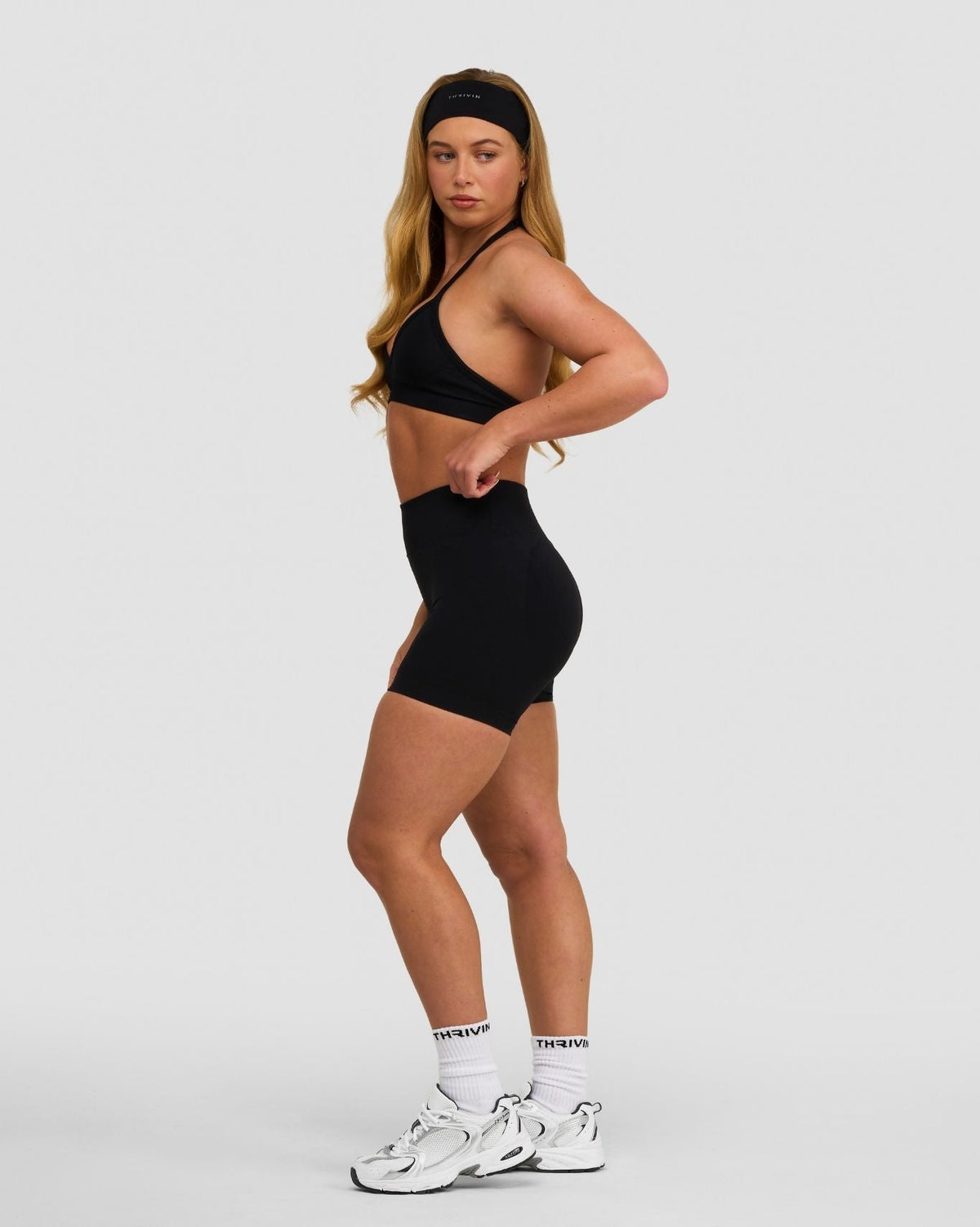 Elevate Sculpting Seamless Adjustable Halter Bra in Night Black, side view styled with matching shorts