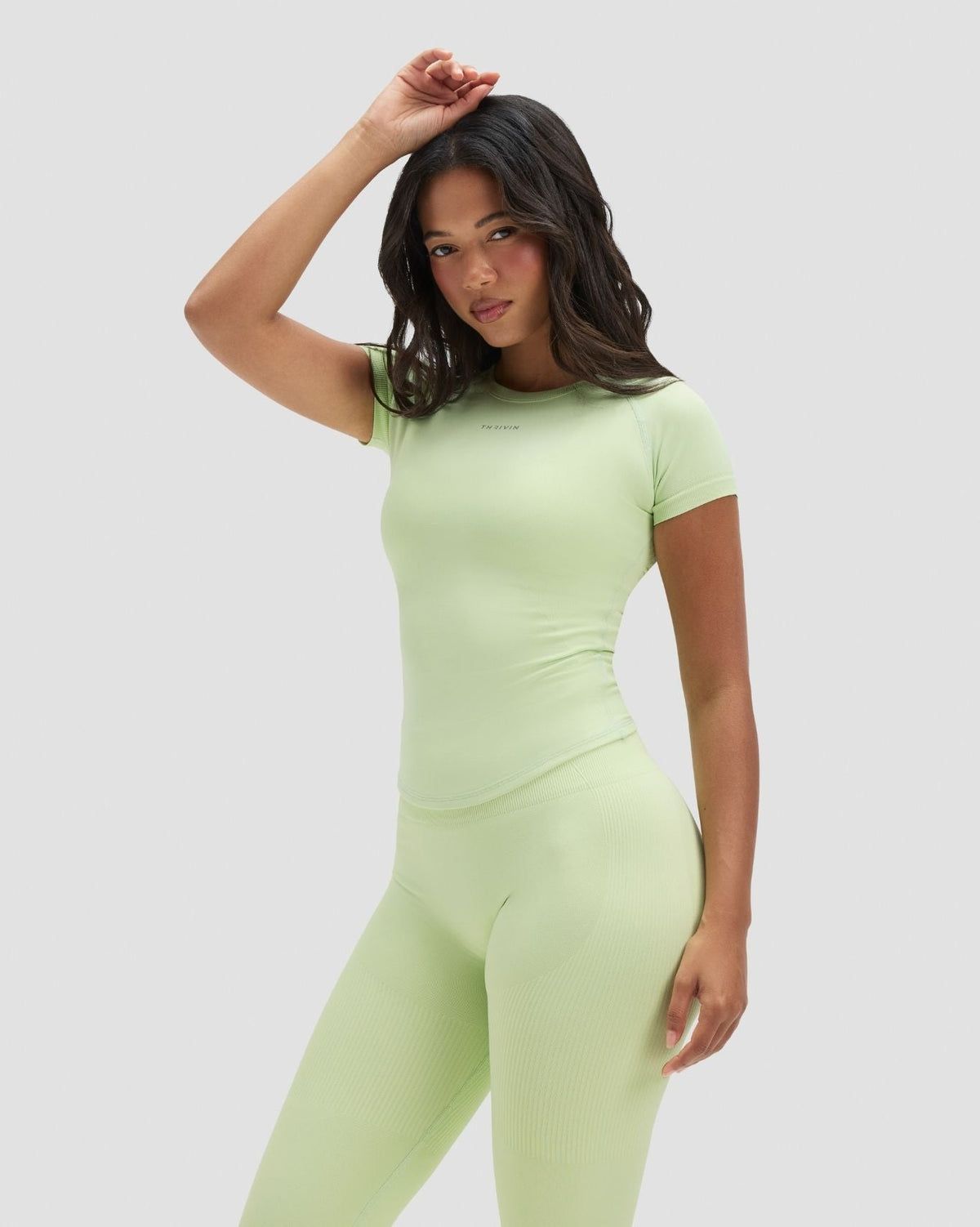 Elevate Compression T-Shirt in Pistachio Green, front view, hand in hair