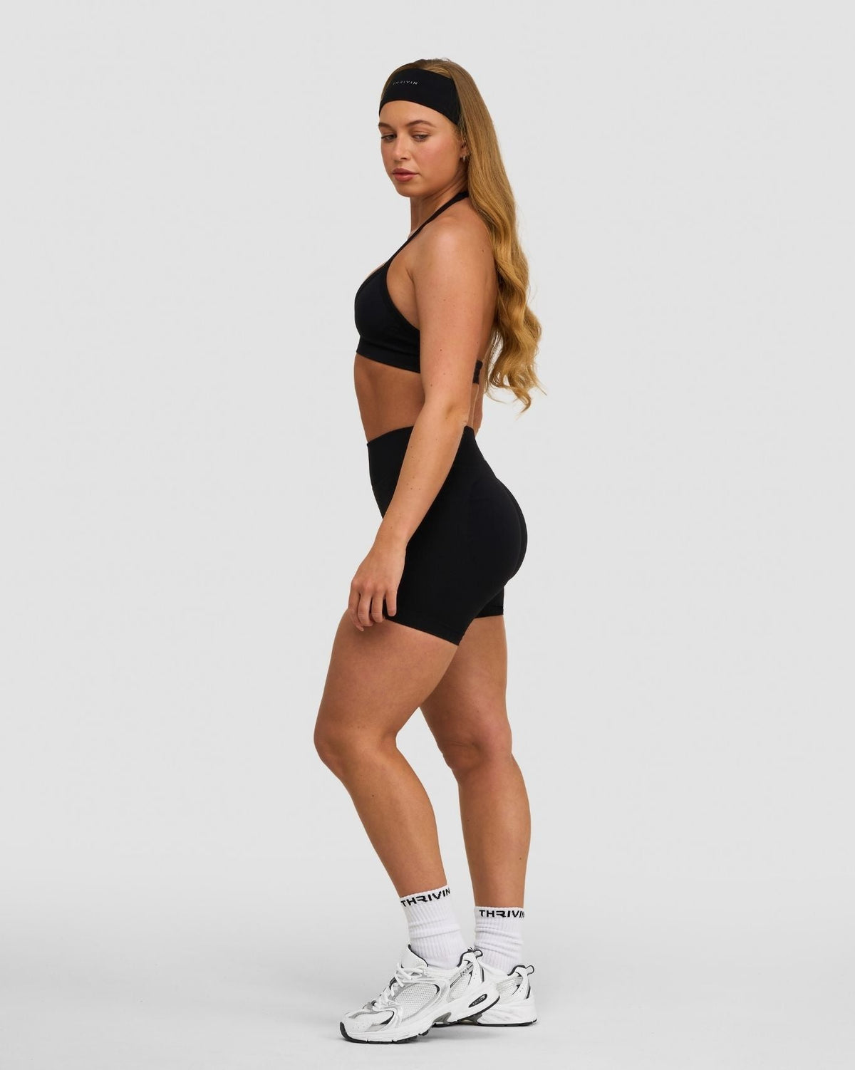Elevate Sculpting Seamless Adjustable Halter Bra in Night Black, side view styled with matching shorts