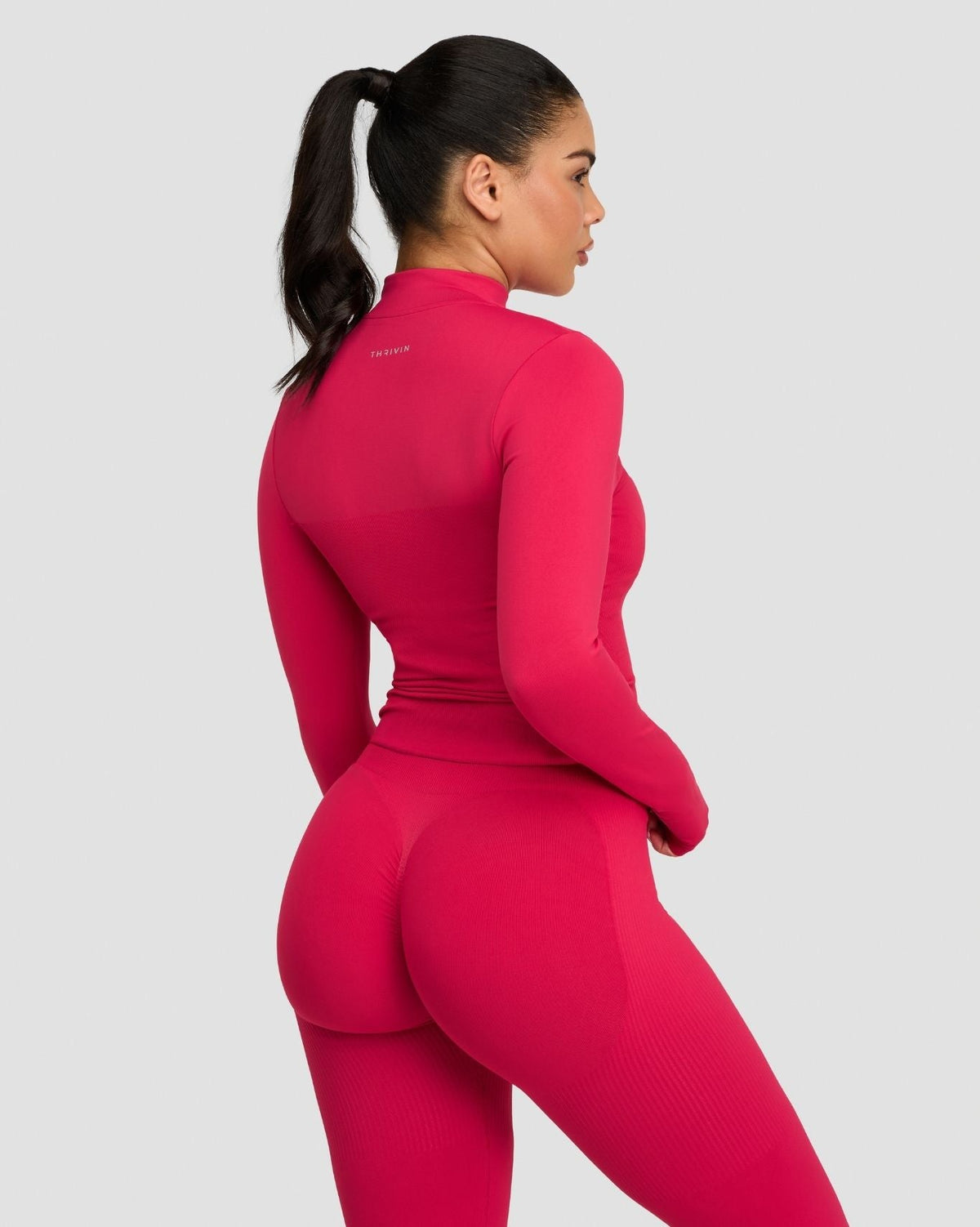 Elevate Compression Long Sleeve Jacket in Strawberry, back three-quarter view with stand collar and matching leggings