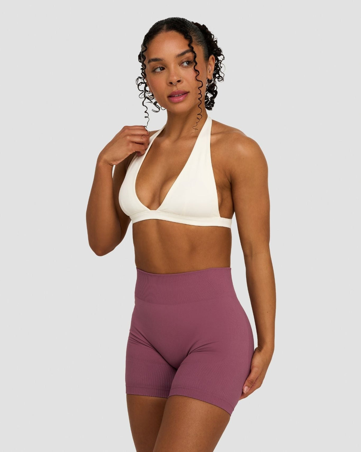 Elevate Sculpting Seamless V-Neck Halter Bra in Cream, close-up front view of deep V-neck, styled with shorts