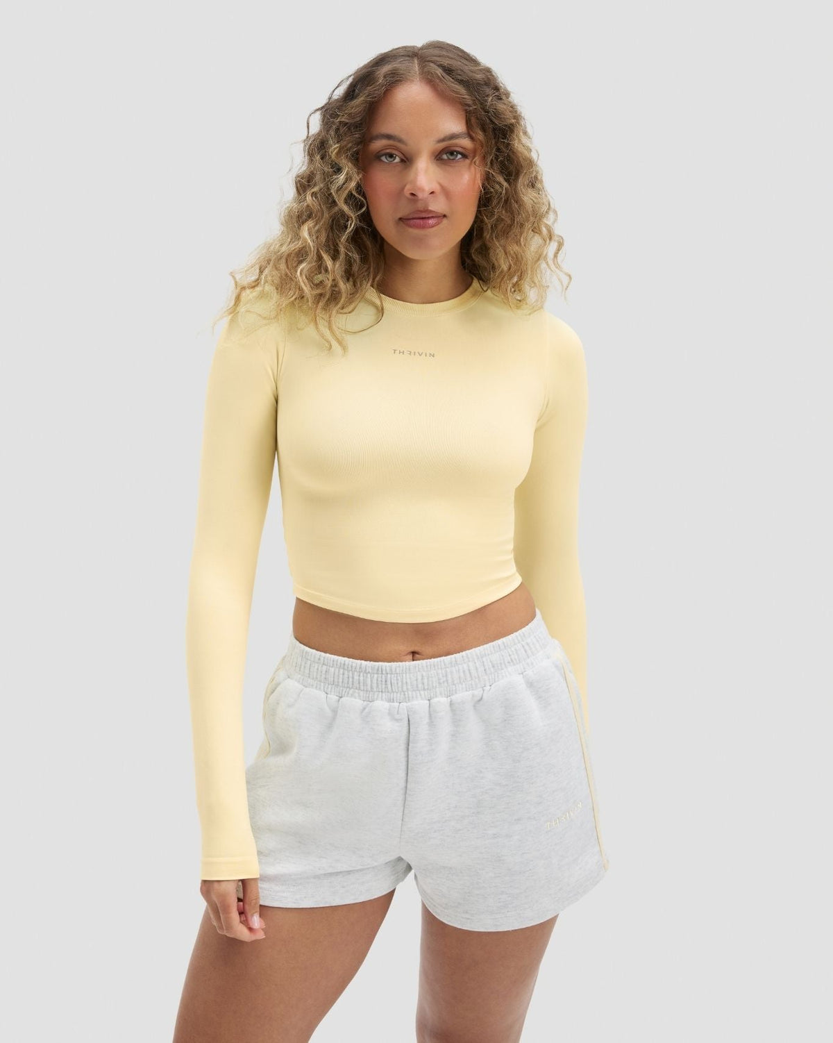 Elevate Compression Long Sleeve Top in Butter Yellow, front view with grey shorts