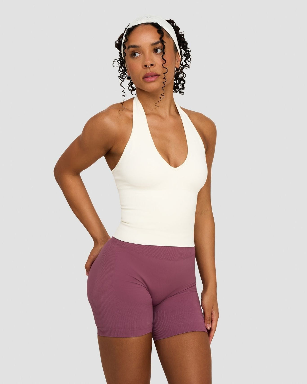 Elevate Sculpting Seamless Halterneck Top in Cream, three-quarter front view of halter neck, hands on hips