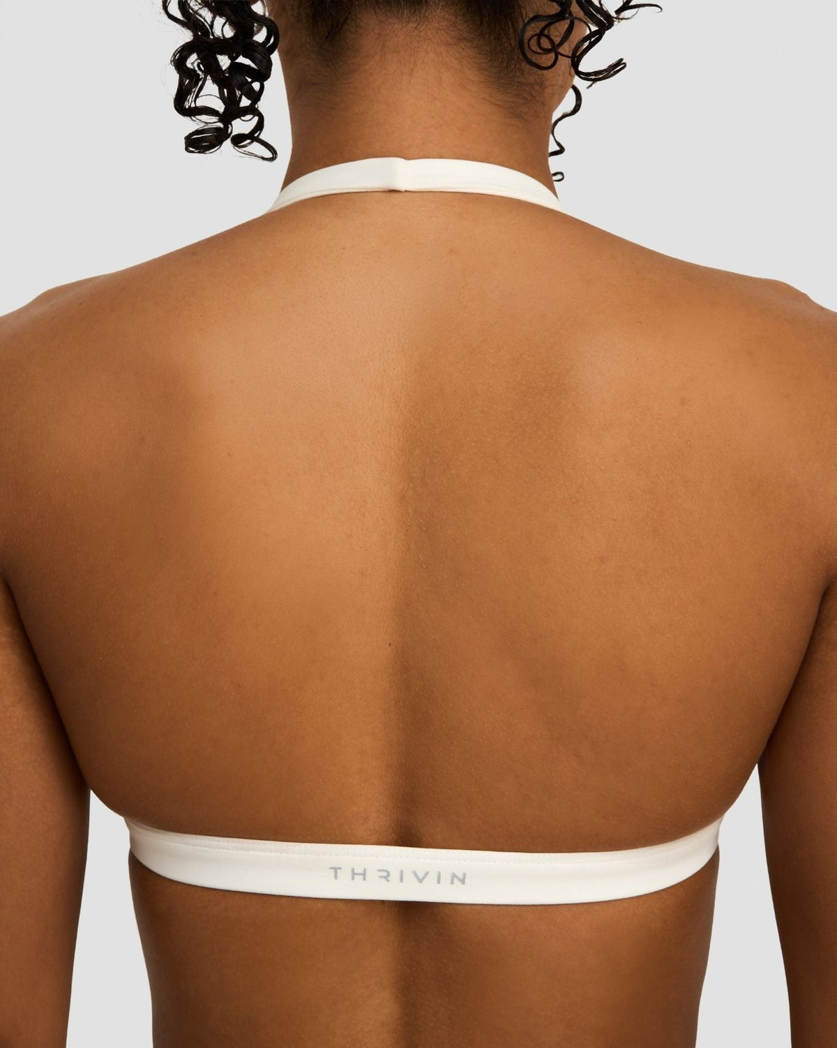 Elevate Sculpting Seamless V-Neck Halter Bra in Cream, back close-up of open back and THRIVIN logo band