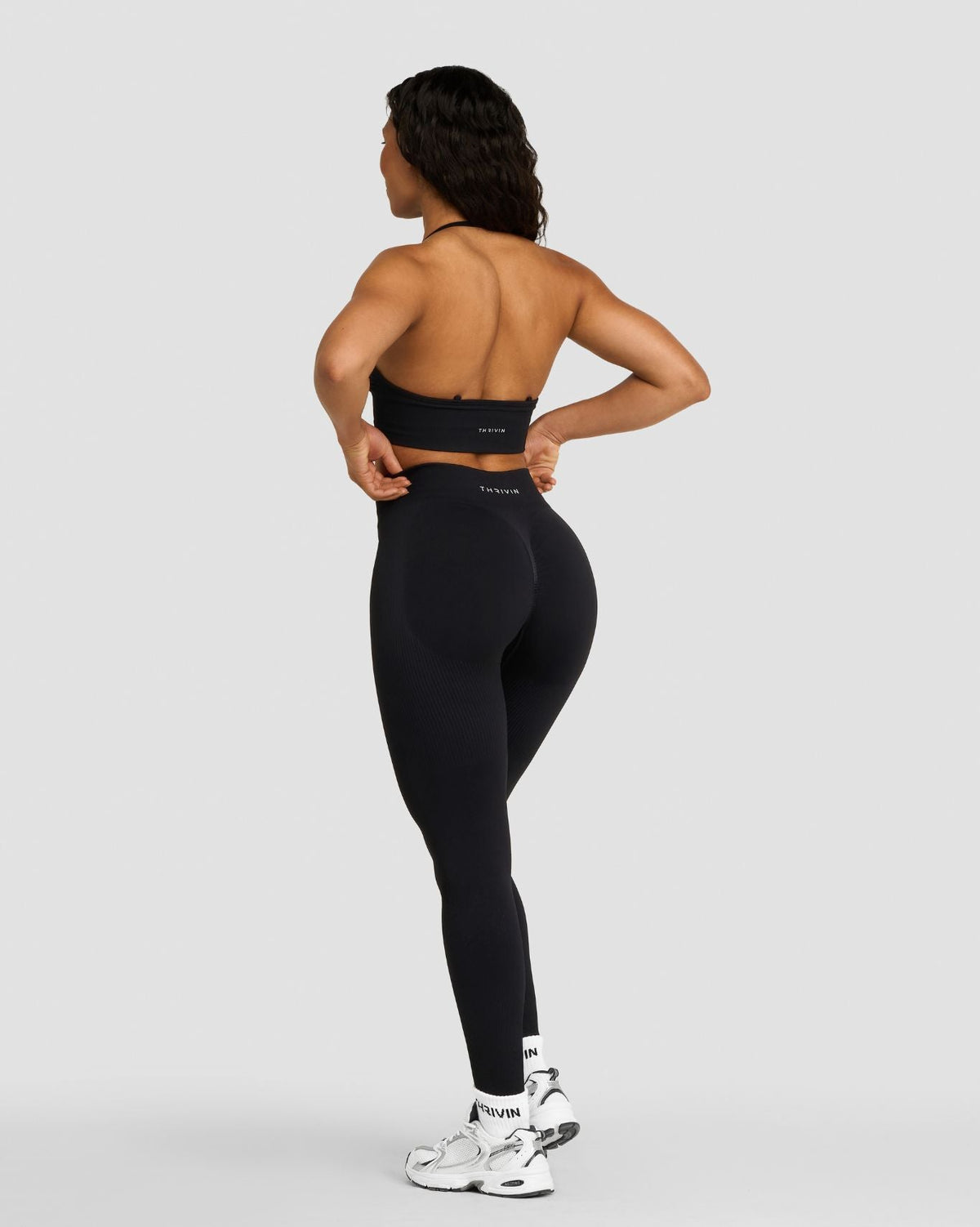 Elevate Sculpting Mid Waist Scrunch Leggings in Night Black, back view with scrunch seam, hands on hips
