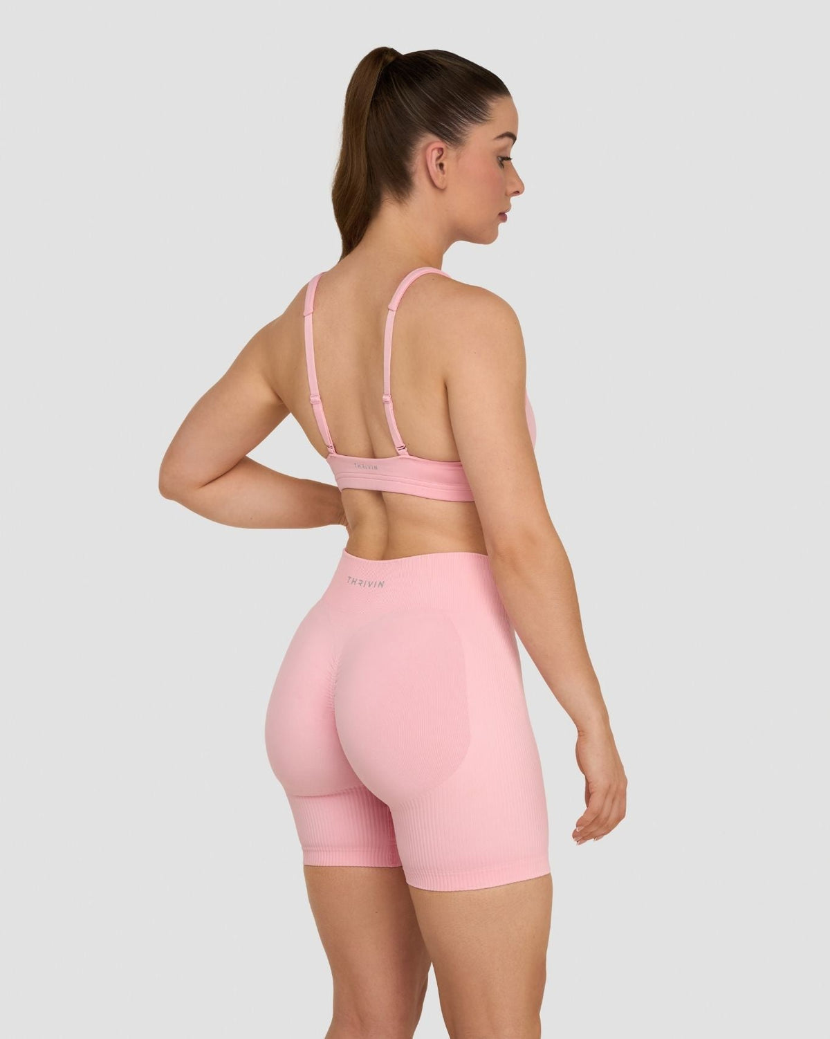Elevate Sculpting Medium Impact Multiway Bra in Cotton Pink, back three-quarter view with hand on hip