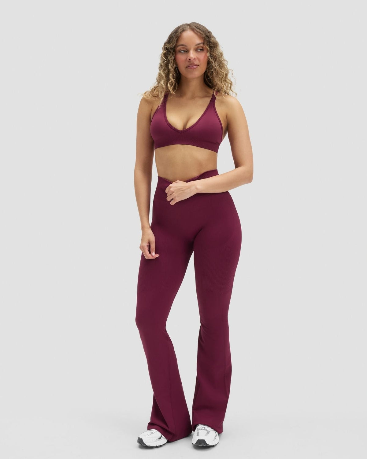 Elevate Sculpting Seamless High Apex Bra in Cherry Berry, full-length front view styled with flared leggings
