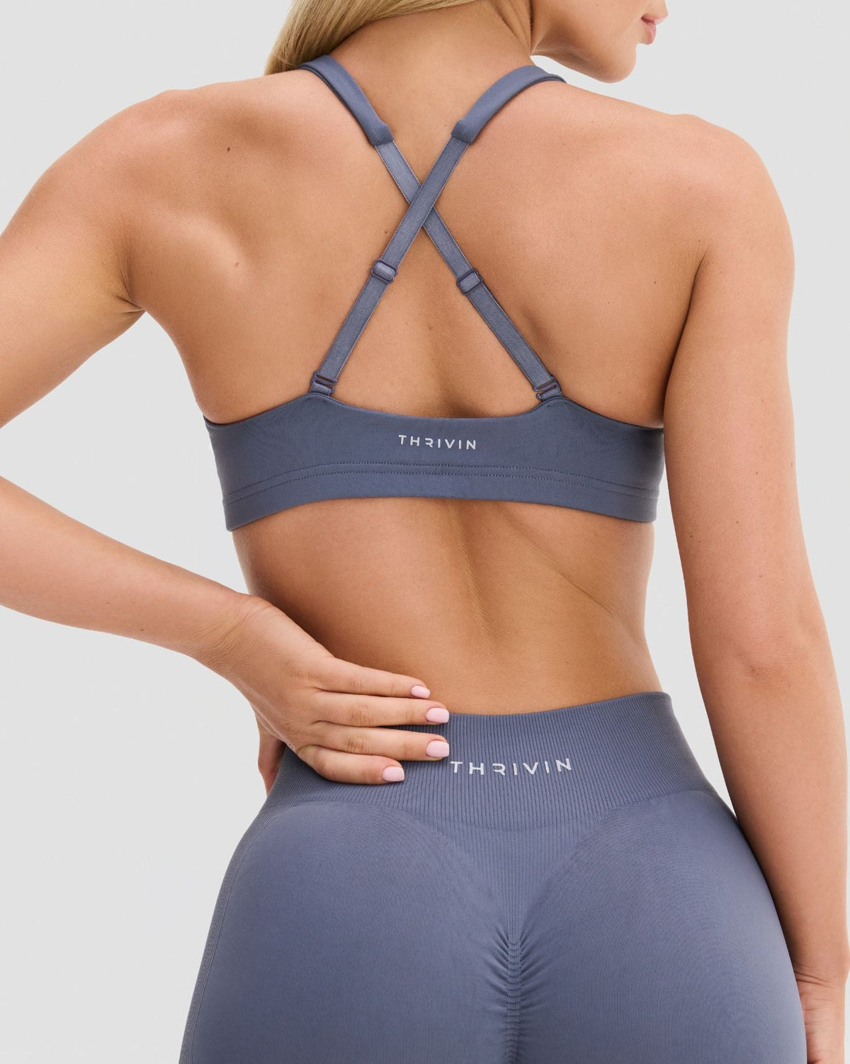 Elevate Sculpting Medium Impact Multiway Bra in Steel Blue, back view of cross-back straps with sliders and Thrivin logo band