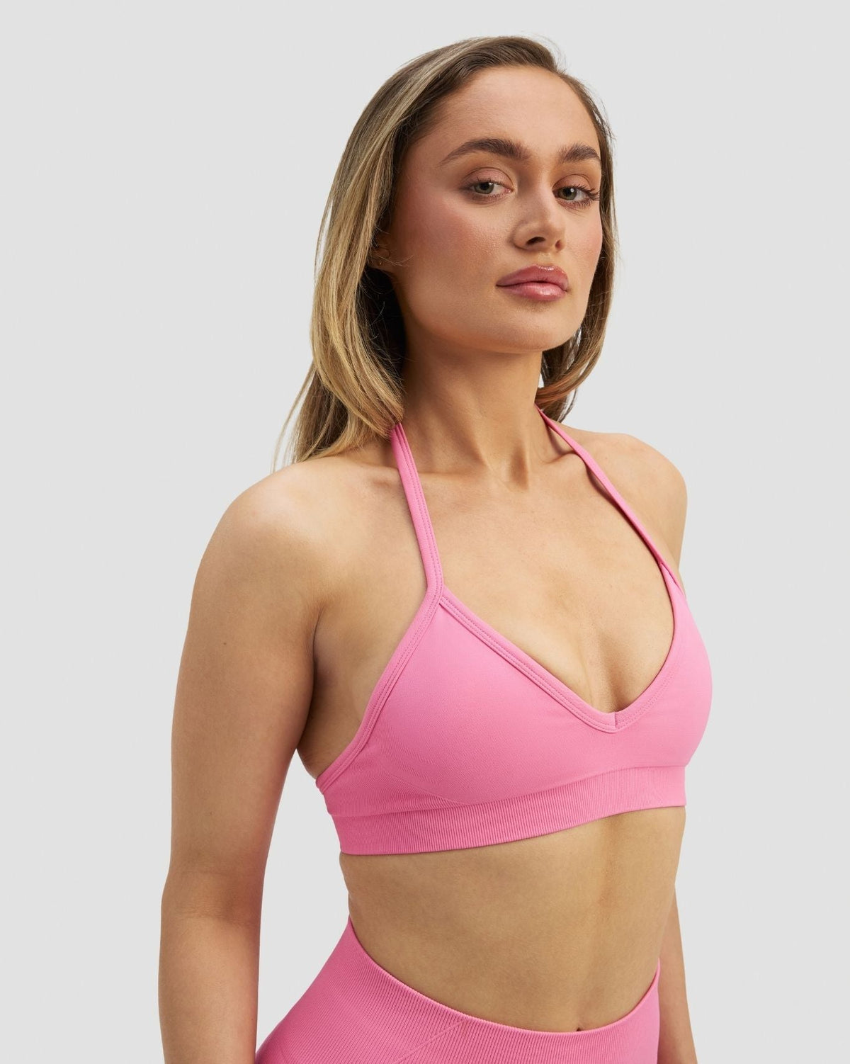 Elevate Sculpting Seamless Adjustable Halter Bra in Bubble Pink, front close-up of V-neckline and halter strap