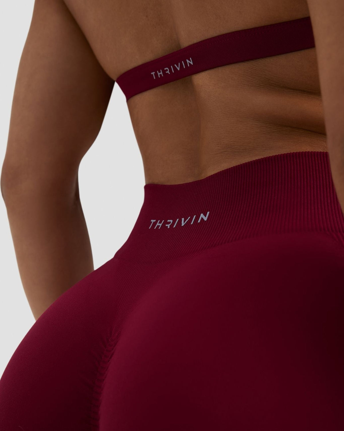 Elevate Sculpting Mid Waist Scrunch Shorts in Raspberry, back close-up of waistband and THRIVIN logo