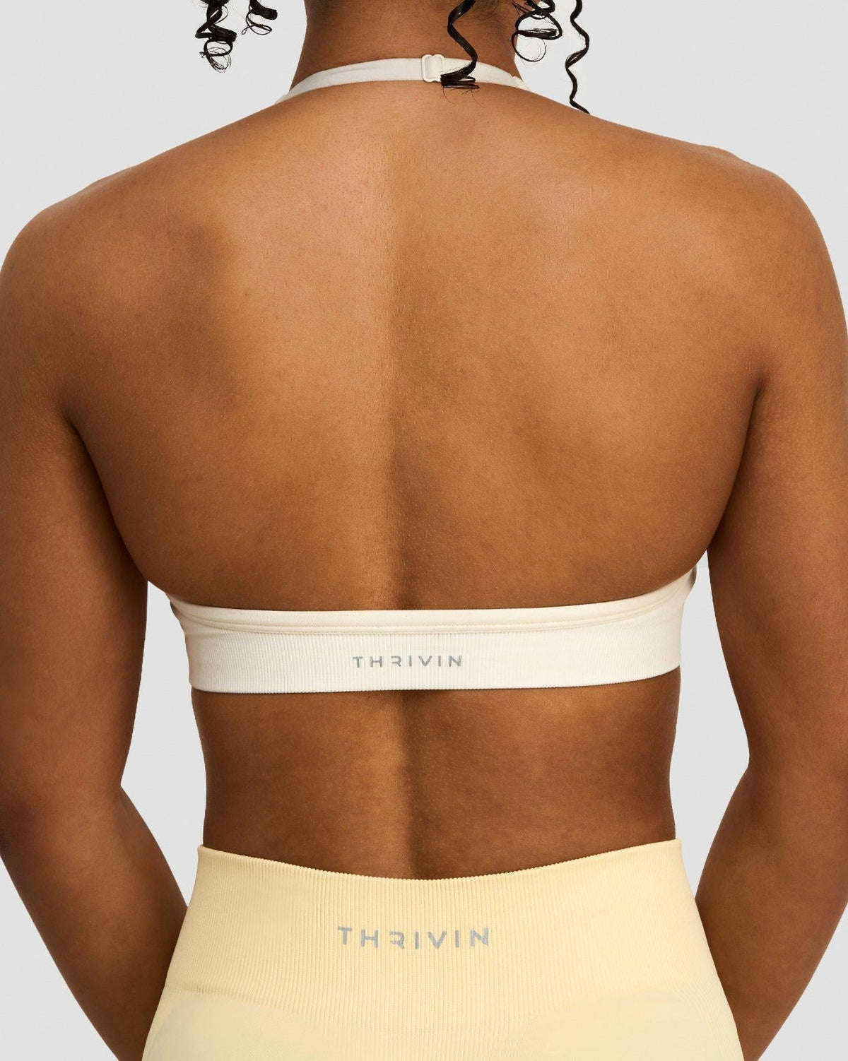 Elevate Sculpting Seamless Adjustable Halter Bra in Cream, back close-up of band with THRIVIN logo