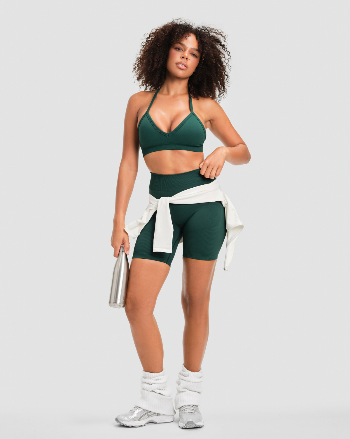 Elevate Sculpting Mid Waist Scrunch Shorts in Pine Green, full-length front view styled with matching halter sports bra