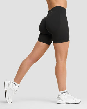 Elevate Sculpting Mid Waist Scrunch Shorts in Charcoal Grey, side view mid-stride with sneakers