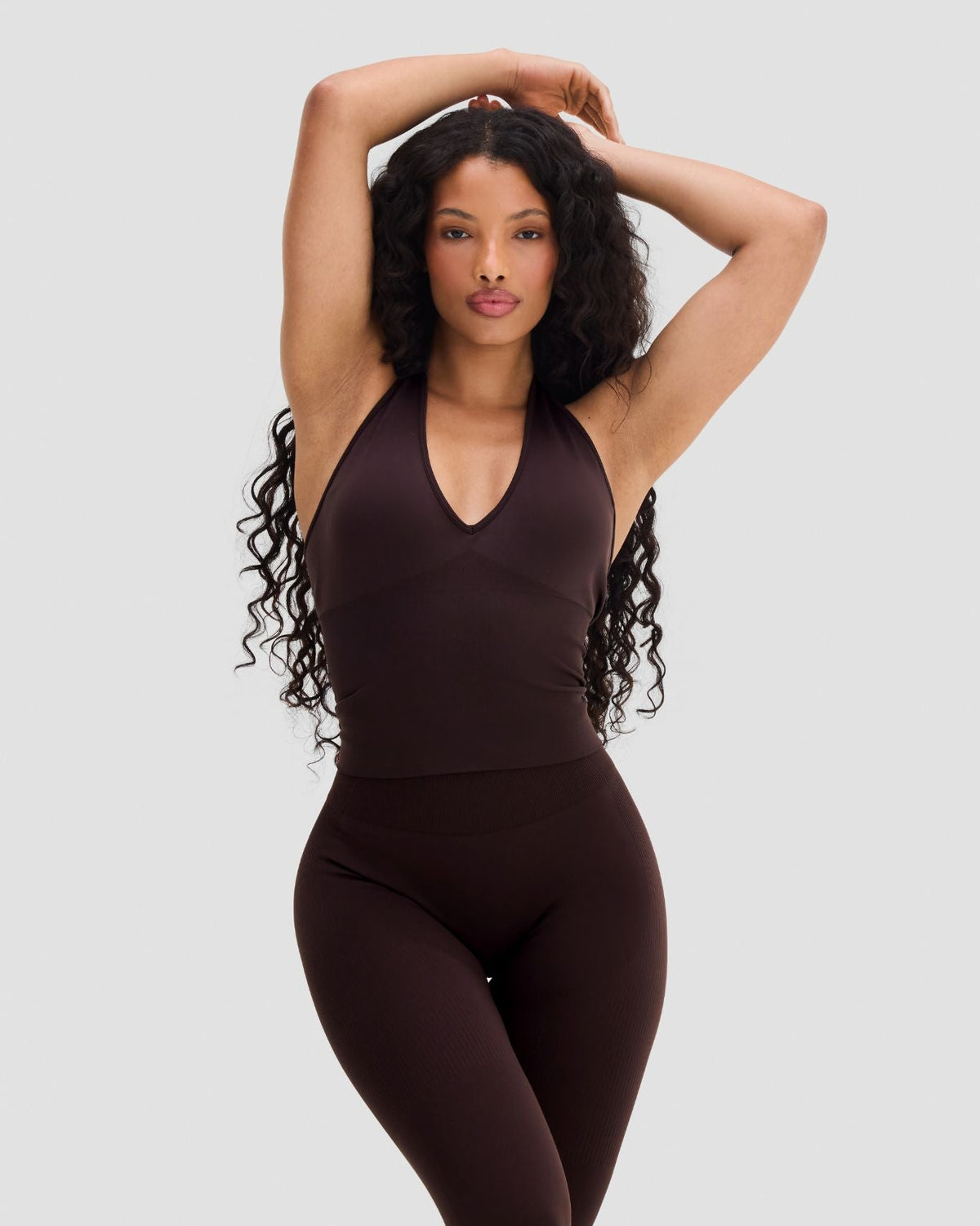 Elevate Sculpting Seamless Halterneck Top in Coffee Brown, front view with arms raised, styled with leggings