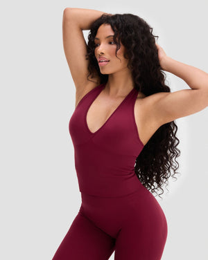 Elevate Sculpting Seamless Halterneck Top in Fine Wine Red, front view with arms raised, styled with leggings