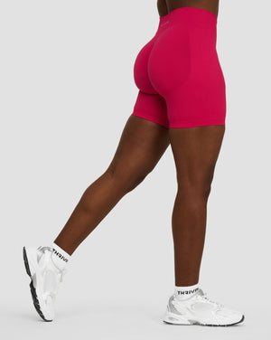 Elevate Sculpting Mid Waist Scrunch Shorts in Strawberry, side view in a lunge stance showing the sculpted back seam