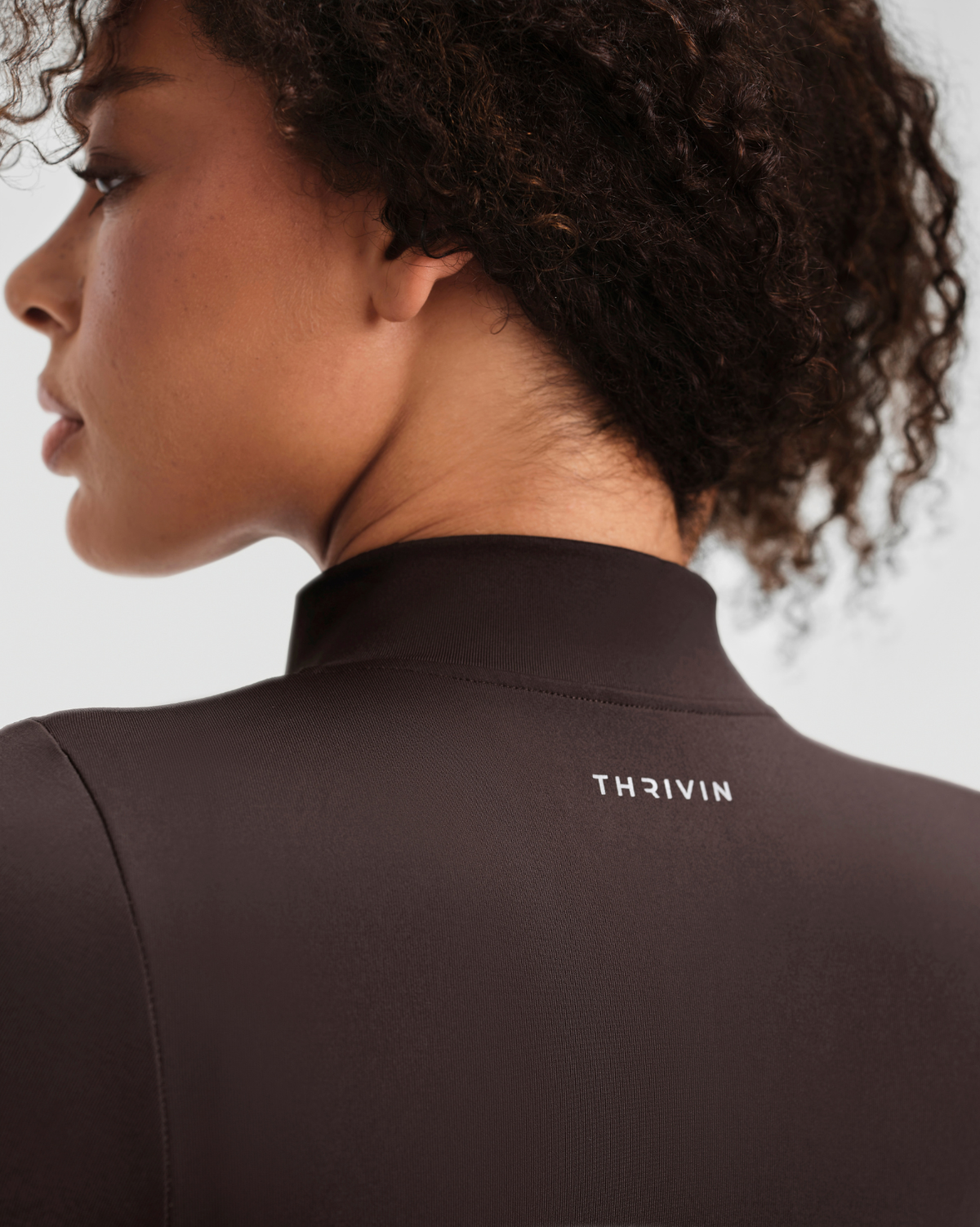 Elevate Compression Long Sleeve Jacket in Coffee Brown, back close-up of the stand collar and Thrivin logo below the neck