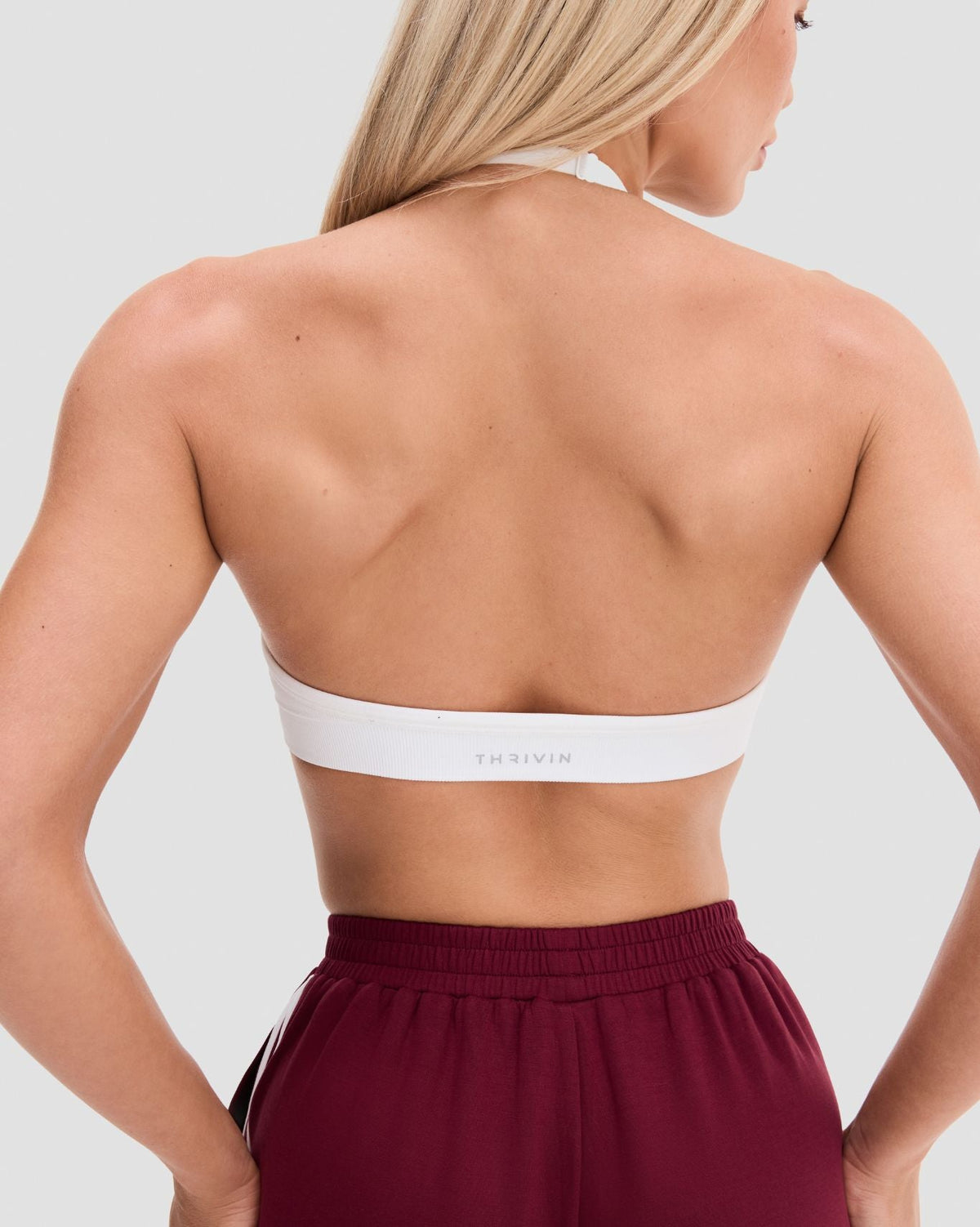 Elevate Sculpting Seamless Adjustable Halter Bra in White, back close-up of open back and Thrivin logo band