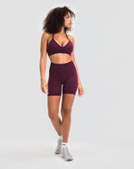 Elevate Sculpting Mid Waist Scrunch Shorts in Winter Plum Red, full-length front view with matching halter sports bra
