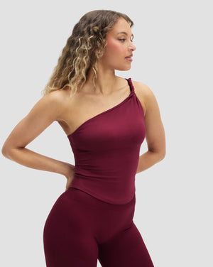Elevate Sculpting Asymmetric Twist Top in Cherry Berry, front view of one shoulder neckline, hands on hips