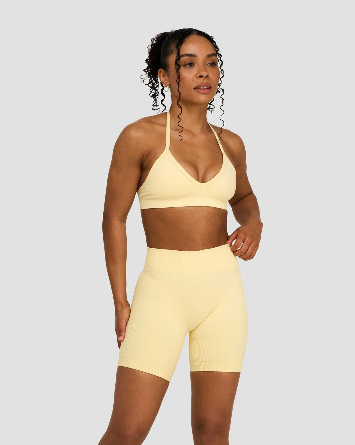 Elevate Sculpting Seamless Adjustable Halter Bra in Butter Yellow, front view styled with matching shorts