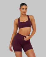Elevate Sculpting Medium Impact Multiway Bra in Winter Plum Red, front view styled with shorts, hand on waist