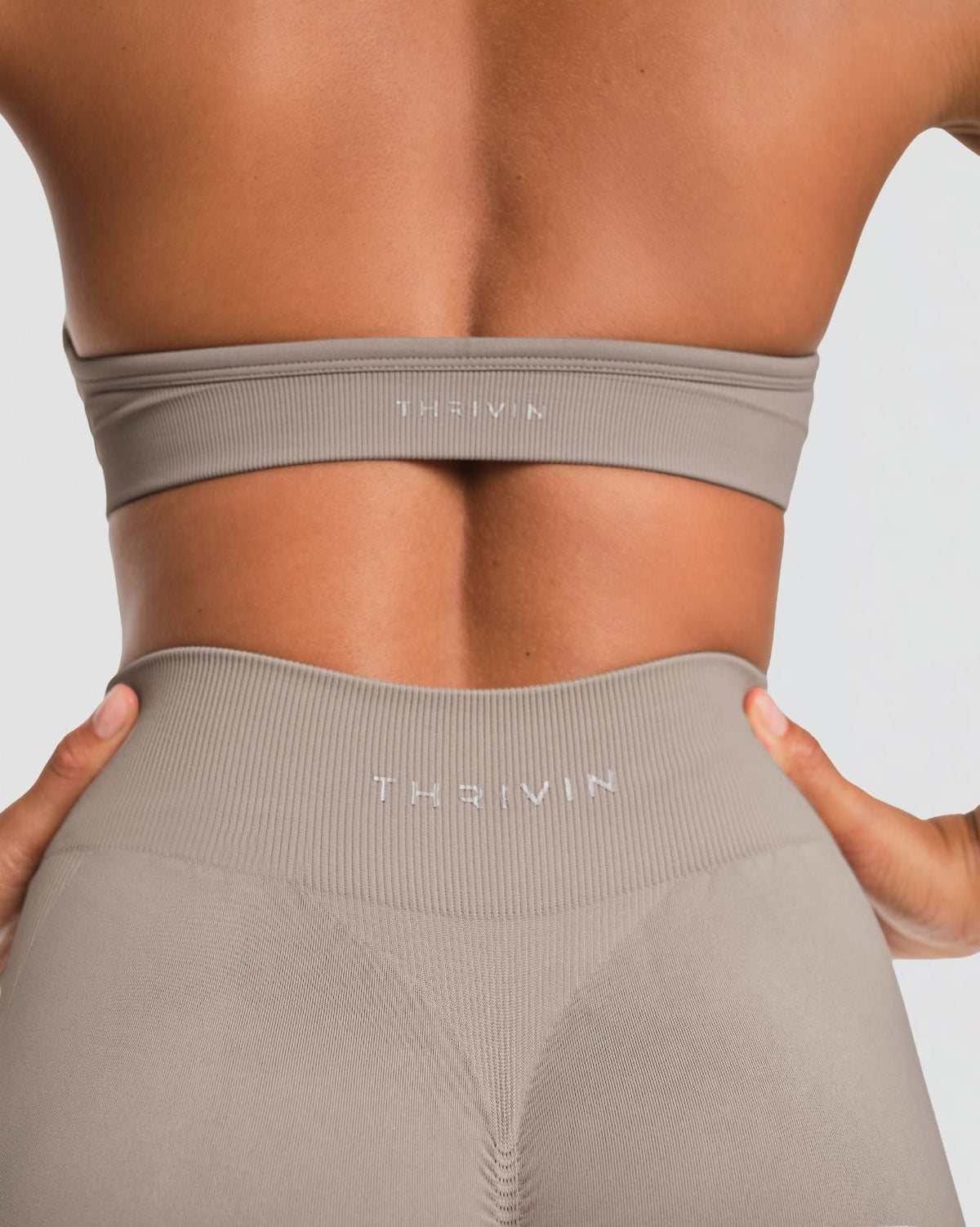 Elevate Sculpting Mid Waist Scrunch Shorts in Latte Grey, back close-up of ribbed THRIVIN logo waistband and scrunch seam