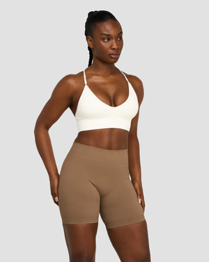 Elevate Multiway Sculpt Seamless Bra in Cream, front view styled with brown shorts