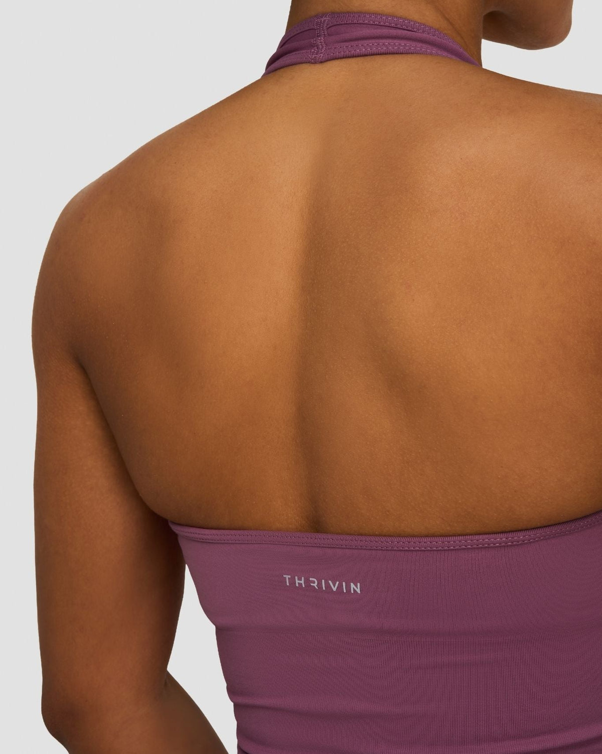 Elevate Sculpting Seamless Halterneck Top in Orchid Mauve, back close-up of open back and THRIVIN logo band