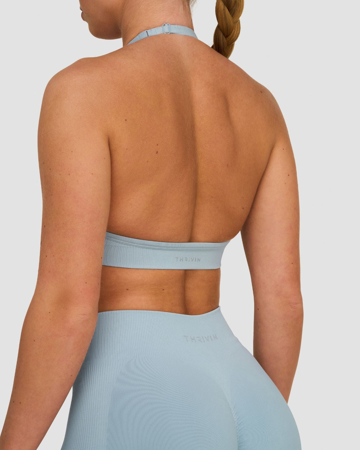 Elevate Sculpting Seamless Adjustable Halter Bra in Blue Haze, back close-up of open back and THRIVIN logo